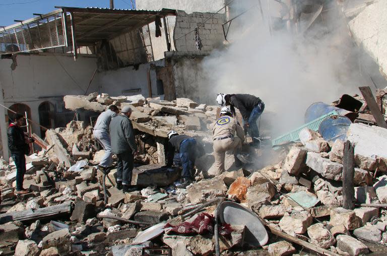 Syrian rescue workers look for survivors from under the rubble at the scene of a reported barrel bomb attack by regime forces in Aleppo, on March 5, 2015