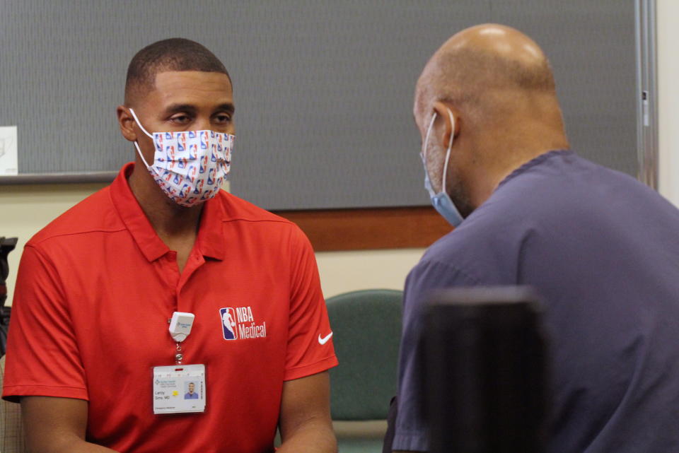 Dr. Leroy Sims, the medical director for the National Basketball Association, speaks with medical personnel after getting the COVID-19 vaccine at Sutter Mills-Peninsula Medical Center in Burlingame, California, U.S., December 18, 2020.   REUTERS/Nathan Frandino