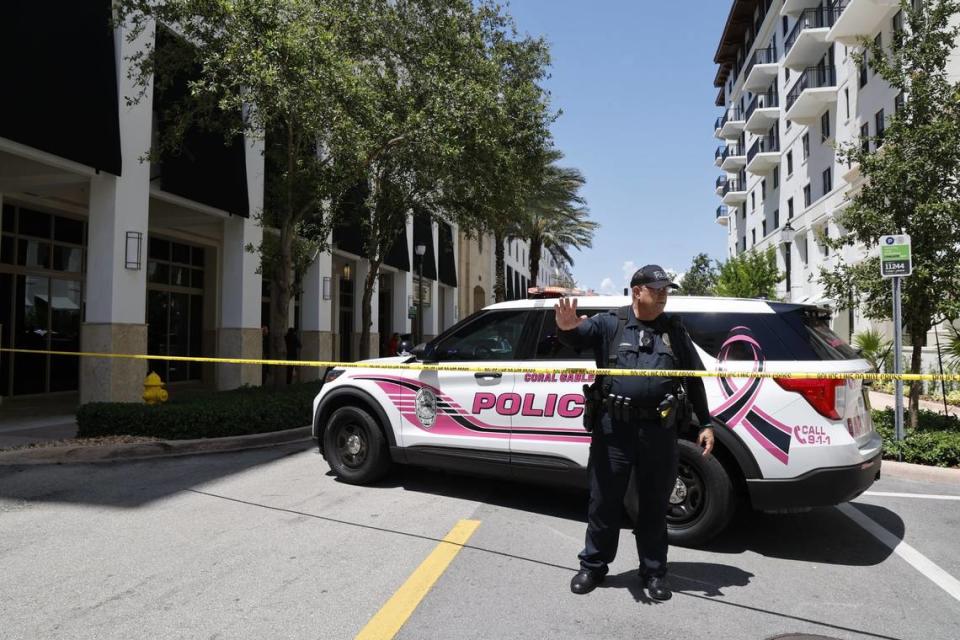 Coral Gables, Florida, June 6, 2024 - Coral Gables Police Officer J. Coleman leads passersby away from the crime scene at the Gables Ponce apartment complex, 310 Granello Ave., where Miami-Dade police say three people were shot in an apartment , two fatally, in Coral Gables, Florida, June 6, 2024. The shooting was a murder-suicide, police say.