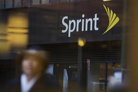 People walk past a Sprint store in New York December 17, 2012. REUTERS/Andrew Kelly