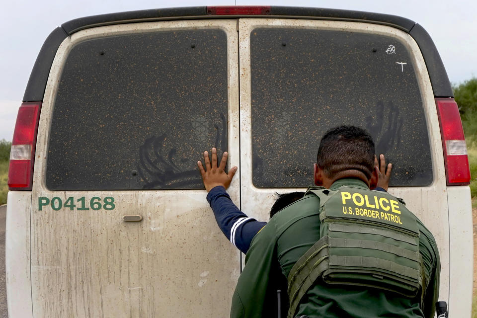 A migrant is searched before transport after being apprehended by U.S. Border Patrol agents at the base of the Baboquivari Mountains, Thursday, Sept. 8, 2022, near Sasabe, Ariz. The desert region located in the Tucson sector just north of Mexico is one the deadliest stretches along the international border with rugged desert mountains, uneven topography, washes and triple-digit temperatures in the summer months. Border Patrol agents performed 3,000 rescues in the sector in the past 12 months. (AP Photo/Matt York)