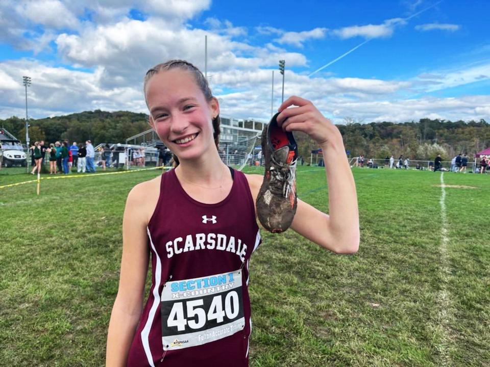 Scarsdale's Sydney Geringer displays one of the two shoes she lost in the mud while running the second girls race at the October 8, 2023 Brewster Bear Cross-Country Classic.