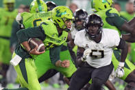 South Florida quarterback Byrum Brown (17) runs past UCF defensive end Malachi Lawrence (51) during the first half of an NCAA college football game Saturday, Nov. 26, 2022, in Tampa, Fla. (AP Photo/Chris O'Meara)