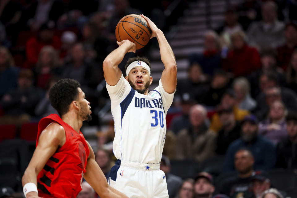 Dallas Mavericks guard Seth Curry, right, shoots a 3-pointer over Portland Trail Blazers forward Toumani Camara during the first half of an NBA basketball game Friday, Dec. 8, 2023, in Portland, Ore. (AP Photo/Howard Lao)