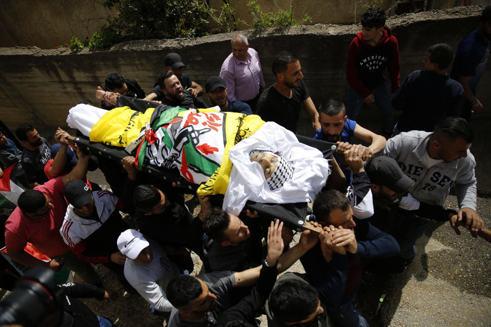 Palestinians carry the body of Osama Mansour during his funeral, in the village of Biddu near the West Bank city of Ramallah, Tuesday, April 6, 2021. Mansour was killed by Israel soldiers at a temporary vehicle checkpoint in the occupied West Bank near Jerusalem. The military said the soldiers thwarted an attempted car-ramming attack in the village of Bir Nabala. But the man's wife, who was in the car with him and was wounded by the gunfire, said the couple followed the soldiers' instructions and posed no threat. (AP Photo/Majdi Mohammed)