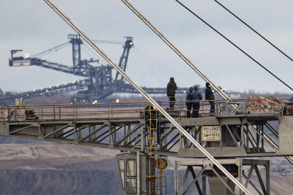 Climate activists are pictured on top of a bucket-wheel excavator at the Hambach opencast lignite mine at Gelsdorf, Germany, Monday, Jan. 16, 2023. Climate activists have occupied the giant digger at the coal mine in western Germany to protest the destruction of the nearby village Luetzerath for the expansion of a separate mine. Energy company RWE told German news agency dpa that four people boarded the digger early Monday. Operations at the Hambach mine have been paused. The action was intended to show solidarity with the people in the village of Luetzerath. (Henning Kaiser/dpa via AP)