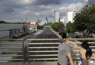 A couple wears protective masks as they walk past a nearly empty boulevard during community quarantine to help curb the spread of the new coronavirus in Manila, Philippines on Monday, March 30, 2020. The new coronavirus causes mild or moderate symptoms for most people, but for some, especially older adults and people with existing health problems, it can cause more severe illness or death. (AP Photo/Aaron Favila)