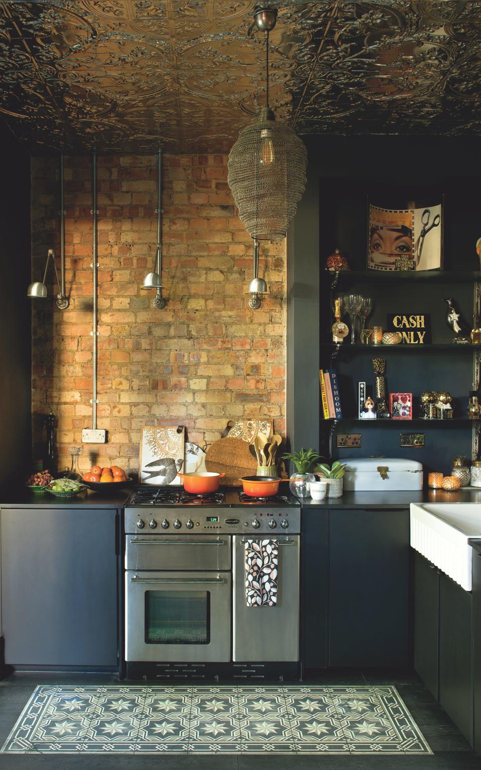 The kitchen is painted black (Zeitgeist from Craig & Rose); a wall of exposed brick adds warmth. The ‘Cash Only’ sign was painted by the artist @hudsonsigns, whom St George met at a car boot sale. -  Claire Worthy