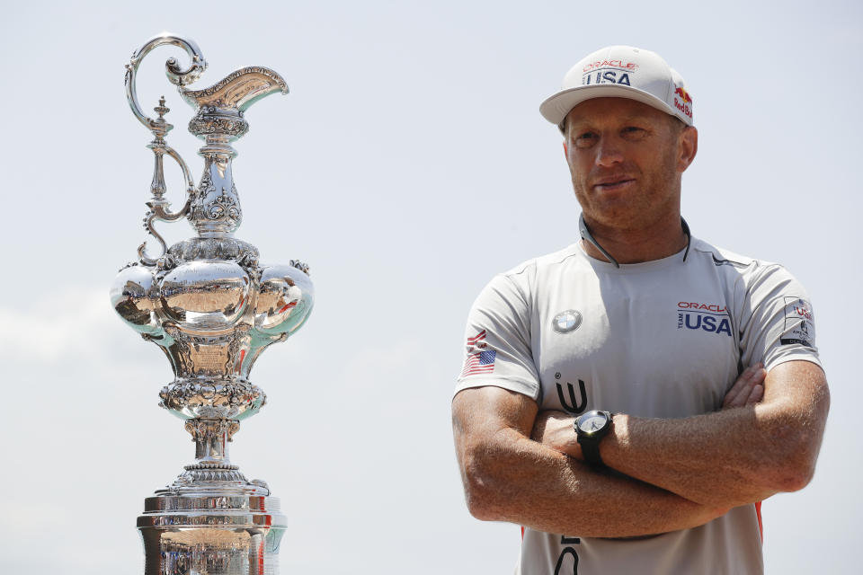 FILE - In this June 16, 2017, file photo, Oracle Team USA skipper and helmsman Jimmy Spithill stands alongside the America's Cup trophy, known as the "Auld Mug," before a news conference in Hamilton, Bermuda. Spithill has signed on as CEO and helmsman of the United States team in SailGP, giving the global league another former America's Cup champion in its stable of stars. (AP Photo/Gregory Bull, File)