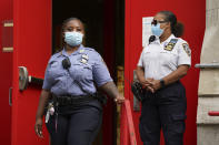 School safety officers stand beside the entrance to New Bridges Elementary School as to New York Mayor Bill de Blasio speaks to reporters after a visit, Wednesday, Aug. 19, 2020, in the Brooklyn borough of New York. Teachers are ramping up pressure on New York City to reconsider its drive to reopen the nation's largest public school system Sept. 10, with their union presenting a list of safety demands. (AP Photo/John Minchillo)