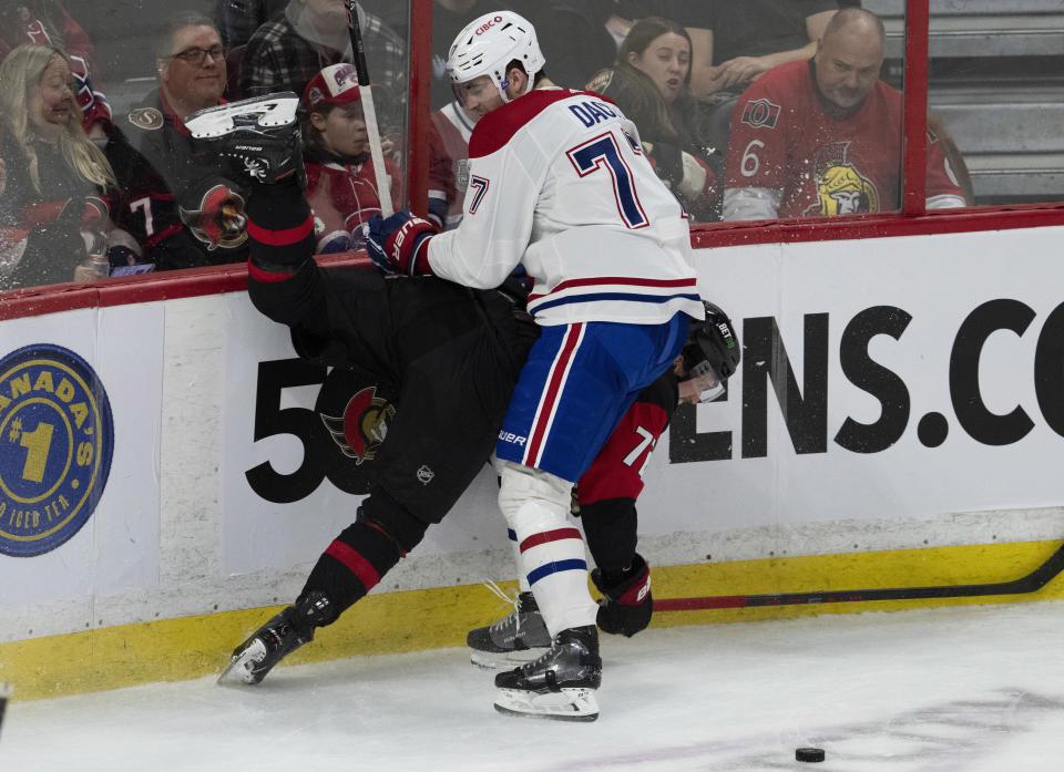 Montreal Canadiens center Kirby Dach, top, collides with Ottawa Senators defenseman Thomas Chabot along the boards during second-period NHL hockey game action Saturday, Jan. 28, 2023, in Ottawa, Ontario. (Adrian Wyld/The Canadian Press via AP)