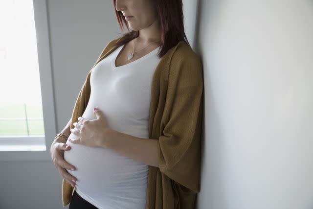 Hero Images / Getty Images Pregnant woman holding stomach.