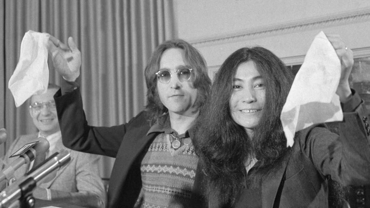  John Lennon and Yoko Ono waving white flags at the press conference to launch Nutopia in 1973. 