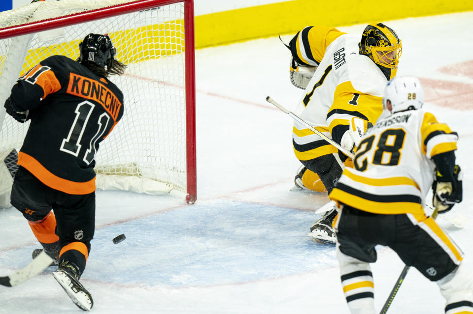 Philadelphia Flyers' Travis Konecny, left, shoots the puck past Pittsburgh Penguins' Casey DeSmith, right, for his third goal during the third period of an NHL hockey game, Friday, Jan. 15, 2021, in Philadelphia. (AP Photo/Chris Szagola)