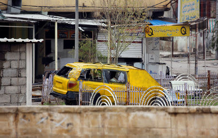 An Islamic State militants car used as a car bomb lies destroyed near Mosul train station in Mosul. REUTERS/Youssef Boudlal