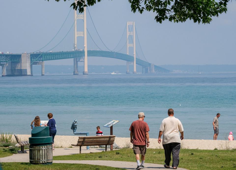 With the Mackinac Bridge as a backdrop, people enjoy the weather and the view of the Straits of Mackinac on July 28, 2021.