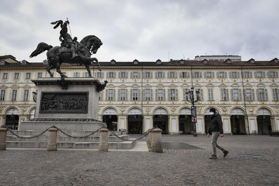 A man wearing a respiratory mask walks past equestrian monument of Emmanuel Philibert in almost deserted piazza San Carlo. The Italian government shutted down majority of stores to halt the spread of COVID-19 coronavirus outbreak. Among other measures people movements are allowed only for work, for buying essential goods and for health reasons. (Photo by Nicolò Campo/LightRocket via Getty Images)