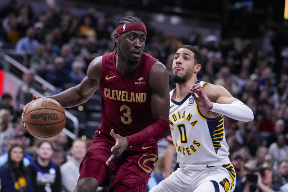 Cleveland Cavaliers guard Caris LeVert (3) drives on Indiana Pacers guard Tyrese Haliburton (0) during the first half of an NBA basketball game in Indianapolis, Monday, March 18, 2024. (AP Photo/Michael Conroy)