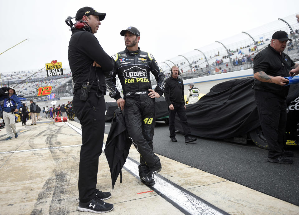 Jimmie Johnson, center, talks with crew chief Chad Knaus, left, during a weather delay in the NASCAR Cup series auto race, Sunday, May 6, 2018, at Dover International Speedway in Dover, Del. (AP Photo/Nick Wass)