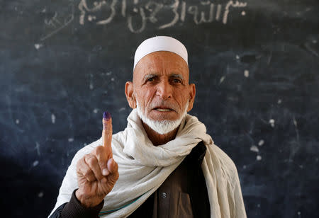 An Afghan man poses for a picture after casting his vote during parliamentary elections at a polling station in Kabul, Afghanistan, October 20, 2018. REUTERS/Mohammad Ismail