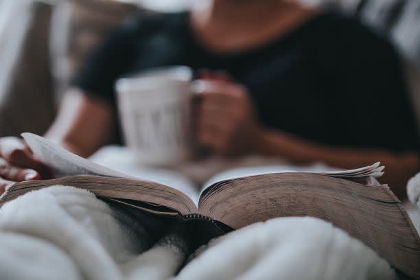 man relaxing with book and coffee