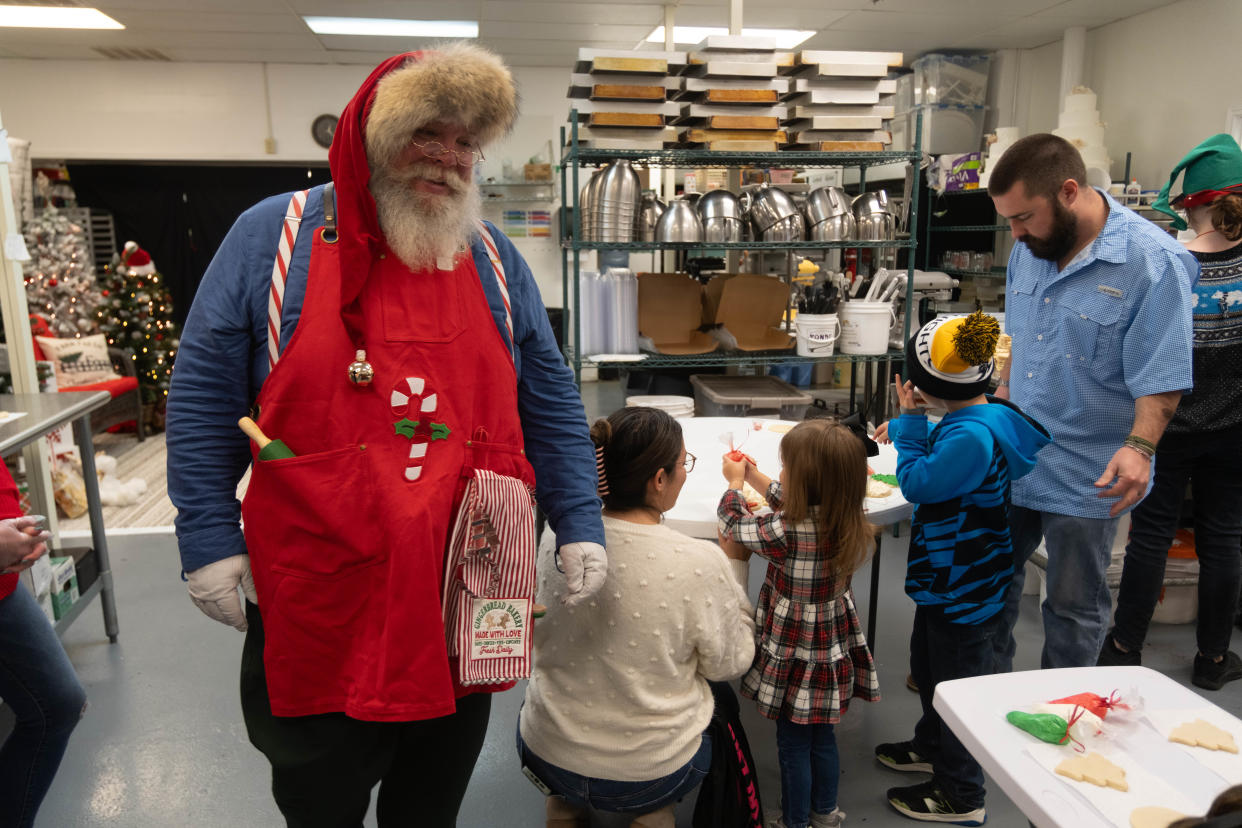 Santa inspects cookies being decorated for him Saturday at the Cake Company of Canyon.