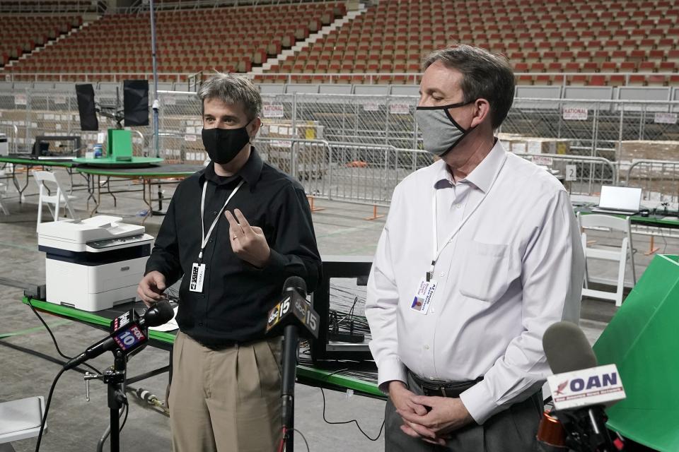 Cyber Ninjas owner Doug Logan, left, a Florida-based consultancy, and former Arizona Secretary of State Ken Bennett, right, talk about overseeing a 2020 election ballot audit at the Arizona Veterans Memorial Coliseum, during a news conference Thursday, April 22, 2021, in Phoenix. The equipment used in the November election won by President Joe Biden and the 2.1 million ballots were moved to the site Thursday so Republicans in the state Senate who have expressed uncertainty that Biden's victory was legitimate can recount them and audit the results. (AP Photo/Ross D. Franklin)