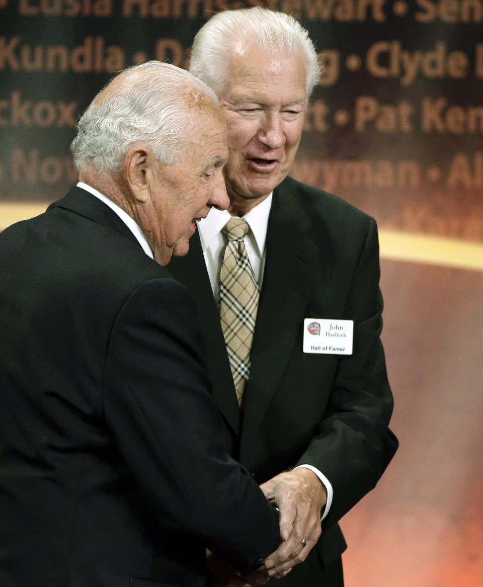 FILE - In this Sept. 8, 2013, file photo, inductee Richie Guerin, left, clasps hands with Hall of Famer John Havlicek, right, after addressing the audience during the enshrinement ceremony for this year's class of the Basketball Hall of Fame, at Symphony Hall in Springfield, Mass. The Celtics said Havlicek died Thursday, April 25, 2019, in Jupiter, Florida. He was 79. (AP Photo/Steven Senne, File)