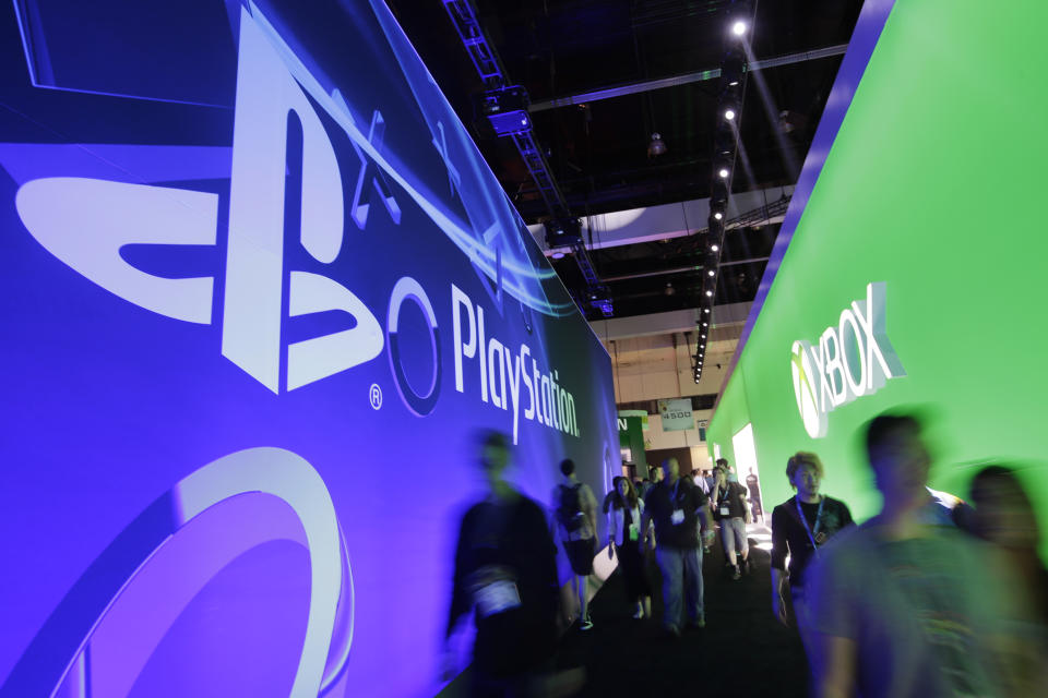 Show attendees walk down the aisle between the Sony and Microsoft booth during the Electronic Entertainment Expo in Los Angeles, Wednesday, June 12, 2013. (AP Photo/Jae C. Hong)