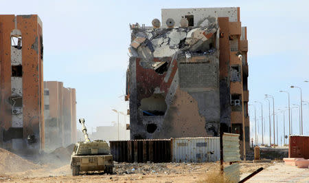 A military vehicle for Libyan forces allied with the U.N.-backed government is stationed in front of ruined buildings at the eastern frontline of fighting with Islamic State militants, in Sirte's neighbourhood 650, Libya, October 21, 2016. REUTERS/Ismail Zitouny