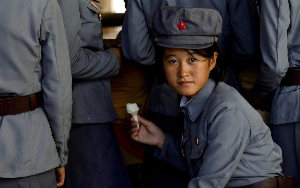 A soldier eats ice cream as she visits a zoo in Pyongyang in 2018. Luxuries like this have become extremely rare in the country's military, with some even defecting due to hunger - DANISH SIDDIQUI /REUTERS