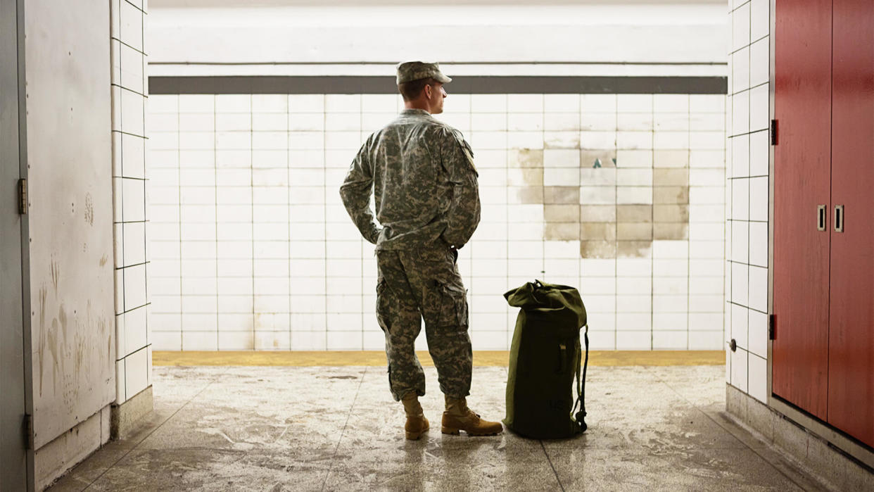 A soldier is waiting for the train.