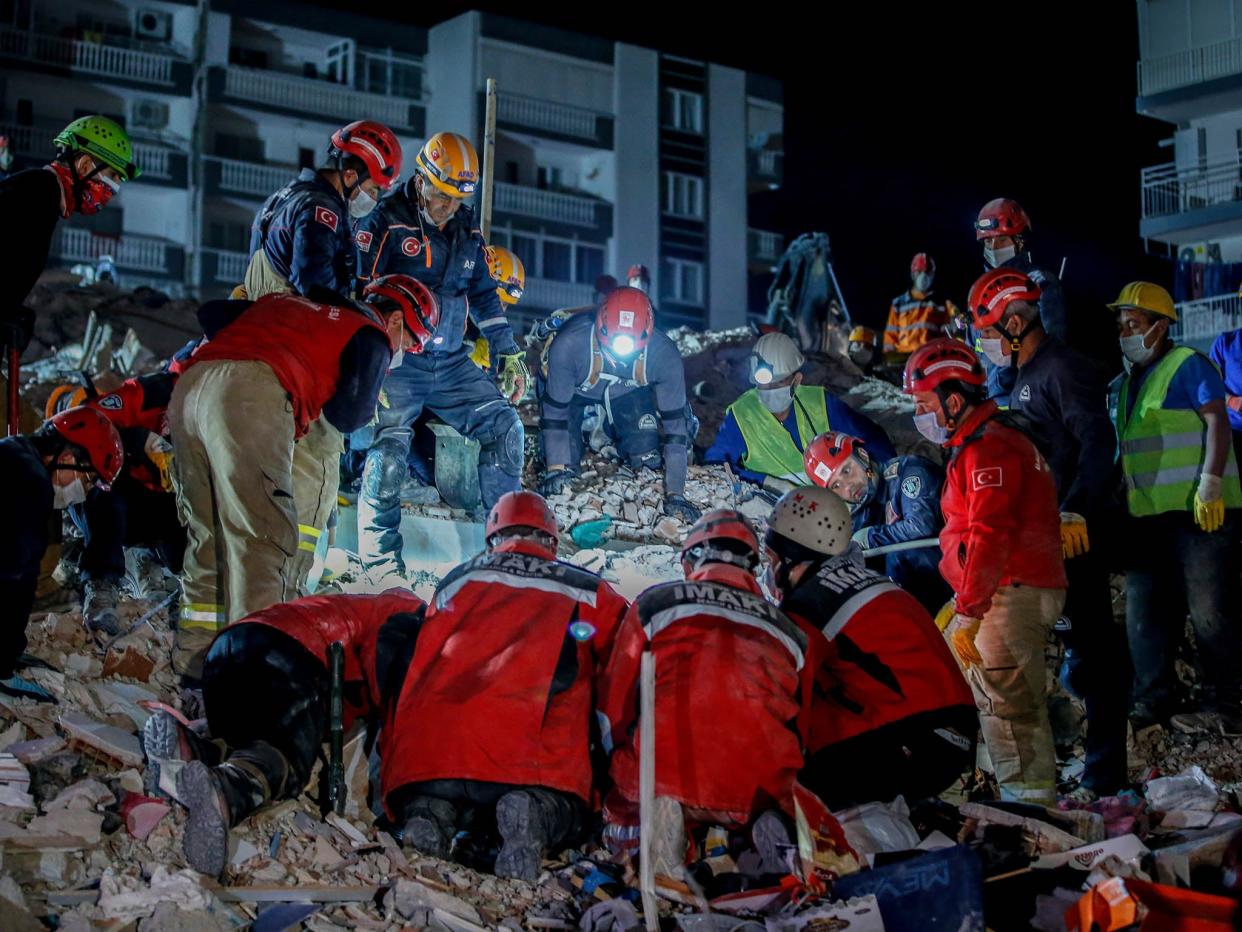 <p>Search and rescue workers continuing to locate people in the wreckage early Sunday morning, 1 November, 2020</p> (Anadolu Agency via Getty Images)