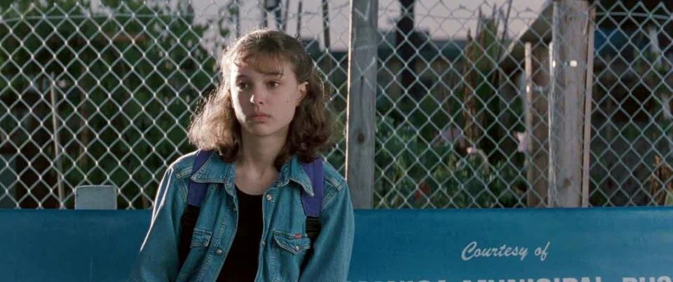 Natalie Portman sitting on a bus bench