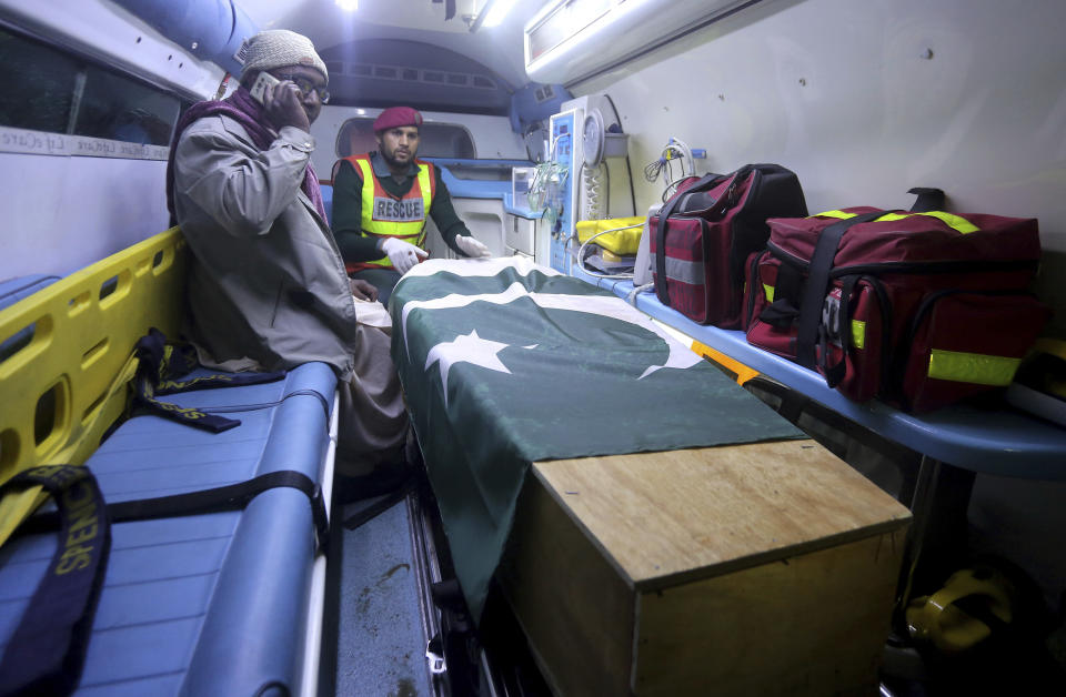 A family member of a Pakistani prisoner Shakir Ullah, who was killed by Indian inmates in an Indian jail, sits next to his body in an ambulance arriving from India at Pakistani-India border post Wagah, near Lahore, Pakistan, Saturday, March 2, 2019. Indian authorities have handed over the body of a Pakistani prisoner Ullah who was beaten to death by Indian inmates this month at an Indian jail apparently in retaliation for the Dec. 14 suicide bombing in Indian-controlled Kashmir that killed 40 soldiers. (AP Photo/K.M. Chaudary)