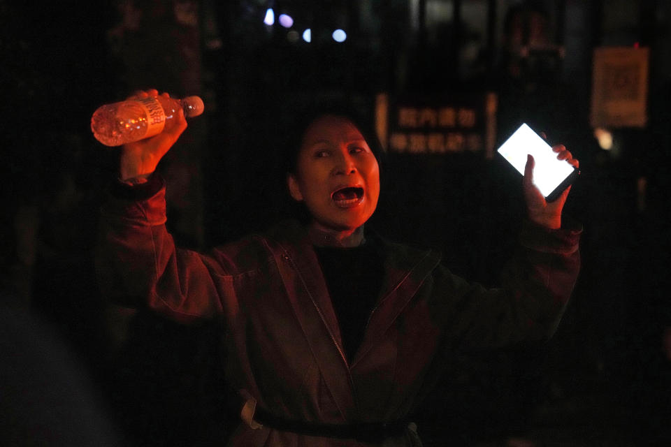 FILE - A woman shouts during a protest in Beijing, Sunday, Nov. 27, 2022. Protesters angered by strict anti-virus measures called for China's powerful leader to resign, an unprecedented rebuke as authorities in at least eight cities struggled to suppress demonstrations that represent a rare direct challenge to the ruling Communist Party. (AP Photo/Ng Han Guan, File)