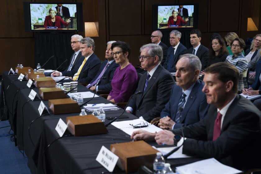 FILE - Sen. Elizabeth Warren, D-Mass., on a screen in the background, questions witnesses about Zelle, during a Senate Banking Committee annual Wall Street oversight hearing, Sept. 22, 2022, on Capitol Hill in Washington. On the panel from left, Wells Fargo & Company CEO and President Charles Scharf, Bank of America Chairman and CEO Brian Thomas Moynihan, JPMorgan Chase & Company Chairman and CEO Jamie Dimon, Citigroup CEO Jane Fraser, Truist Financial Corporation Chairman and CEO William Rogers Jr., U.S. Bancorp Chairman, President, and CEO Andy Cecere, and The PNC Financial Services Group Chairman, President, and CEO William Demchak. (AP Photo/Jacquelyn Martin)