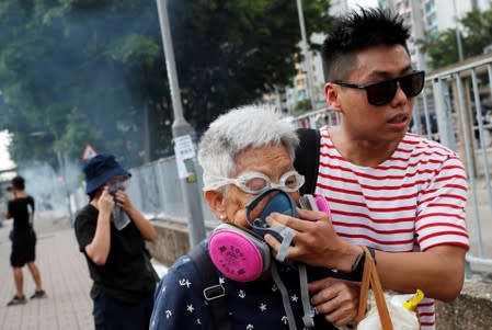 FILE PHOTO: An elderly woman is helped by a demonstrator after police fired tear gas during a demonstration in support of the city-wide strike and to call for democratic reforms at Tin Shui Wai in Hong Kong