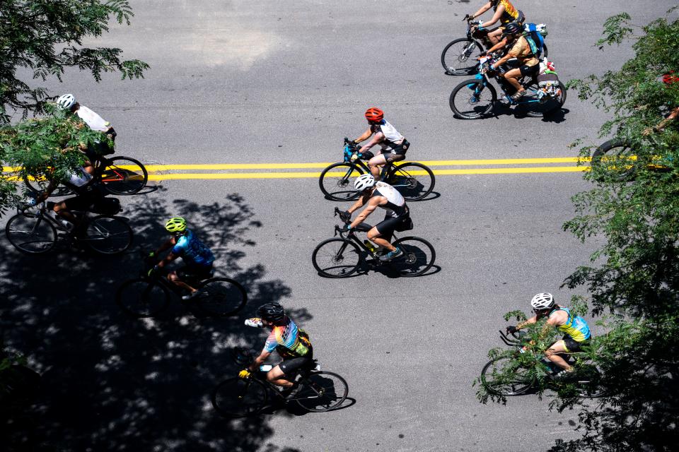 Riders roll along Walnut Street during RAGBRAI 50 on Wednesday, July 26, 2023, in downtown Des Moines.