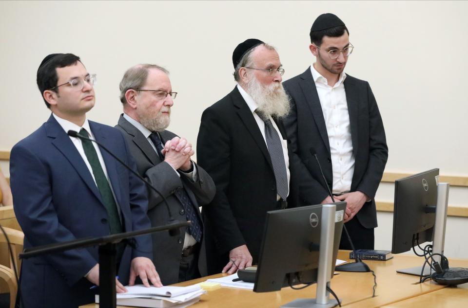 Rabbi Nathanial Sommer, second from right and his son, Aaron Sommer, right, stand with their attorneys Akiva Goldberg, left and Jacob Laufer, during their sentencing at the Rockland County Courthouse in New City, Sept. 20, 2023. 