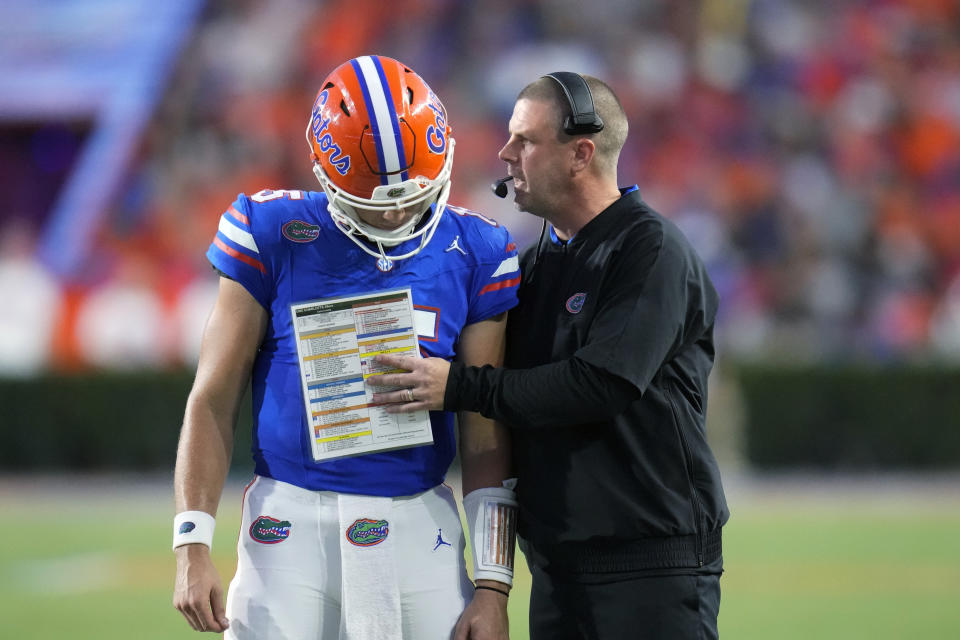 Florida coach Billy Napier, right, talks with quarterback Graham Mertz during the first half of the team's NCAA college football game against Charlotte, Saturday, Sept. 23, 2023, in Gainesville, Fla. (AP Photo/John Raoux)
