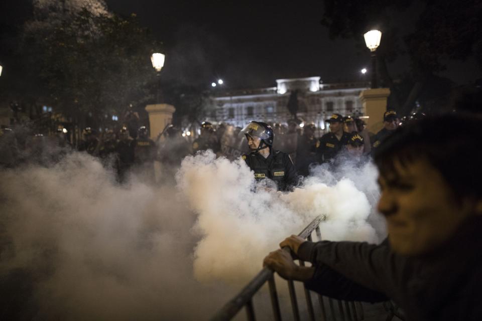 Police launch tear gas at supporters of President Martin Vizcarra to keep them from forcibly entering Congress after the president dissolved the legislature in Lima, Peru, Monday, Sept. 30, 2019. Vizcarra dissolved congress Monday, exercising seldom used executive powers to shut down the opposition-controlled legislature that he accuses of stonewalling attempts to curb widespread corruption. (AP Photo/Rodrigo Abd)