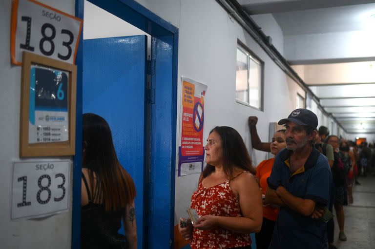 La gente hace cola cerca de Rocinha, la favela más grande de Río de Janeiro, Brasil, el 30 de octubre de 2022, durante la segunda vuelta de las elecciones presidenciales. Brasil elige a su próximo presidente en una segunda vuelta de suspenso entre el actual presidente Jair Bolsonaro y Luiz Inacio Lula da Silva. 