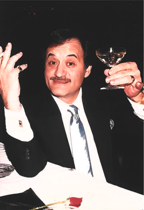 An old image of Sam Pace holding a champagne glass.