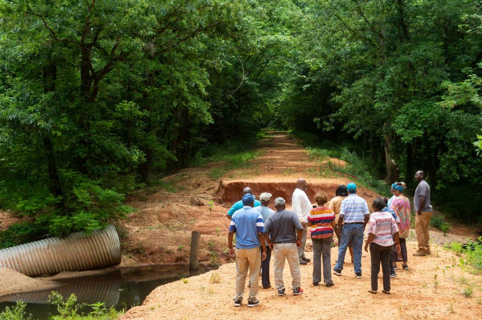 Residents check out a washed out road that leads to the Alabama River Ferry on county road 49 in Packers Bend, Ala., on Thursday, June 1, 2023.