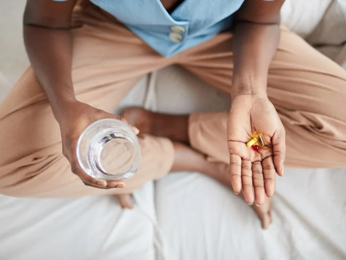 A woman taking vitamins.