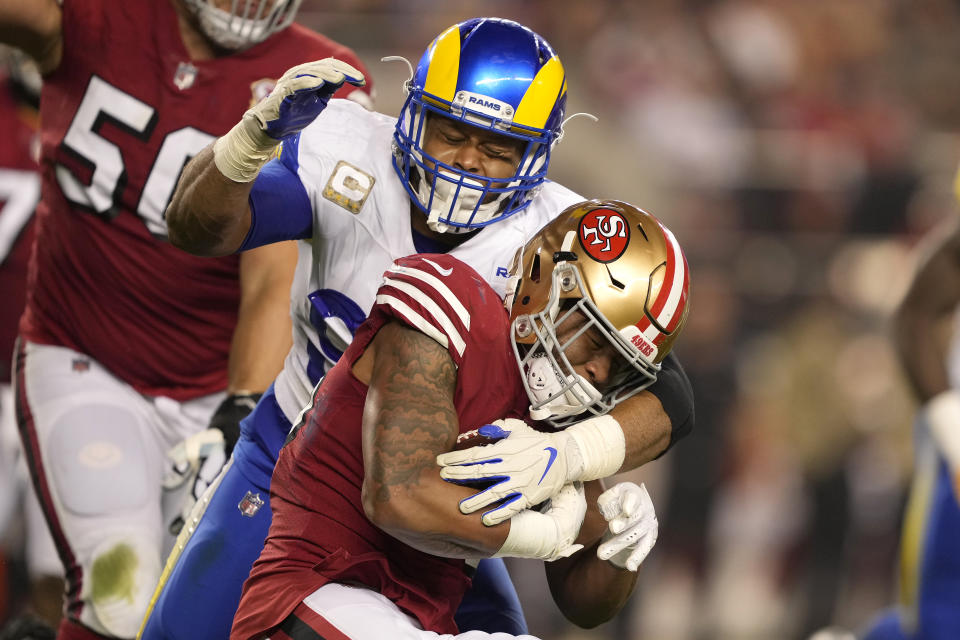 Los Angeles Rams defensive end Aaron Donald, top, tackles San Francisco 49ers running back Elijah Mitchell during the first half of an NFL football game in Santa Clara, Calif., Monday, Nov. 15, 2021. (AP Photo/Tony Avelar)