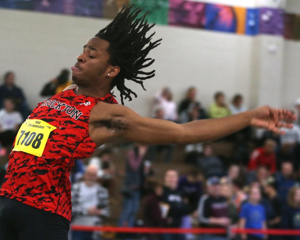 Brockton’s Christensen Paul’s hair flies out during the long jump at the MIAA Meet of Champions at the Reggie Lewis Track Center in Boston on Saturday, Feb. 25, 2023.