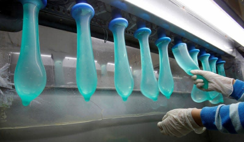 FILE PHOTO: A worker performs a test on condoms at Malaysia's Karex condom factory in Pontian, 320 km (200 miles) southeast of Kuala Lumpur November 7, 2012. Malaysia's Karex Industries is the world's largest condom maker by volume. Picture taken November 7, 2012. REUTERS/Bazuki Muhammad/File Photo