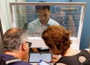 French tourists Marc and Isabelle Rigaud use an automated translation window at the Seibu-Shinjuku station in Tokyo